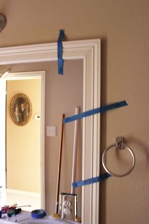 a mirror with blue tape taped around it and some tools on the table in front of it