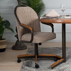 an office chair sitting in front of a table with a wine glass on top of it