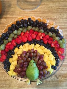 a platter filled with fruits and vegetables on top of a wooden table