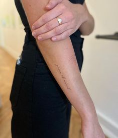 a woman with a tattoo on her arm is holding onto the wrist of another person