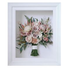 a bouquet of flowers in a white frame