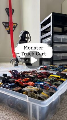 a plastic container filled with toy cars on top of a floor next to a dresser