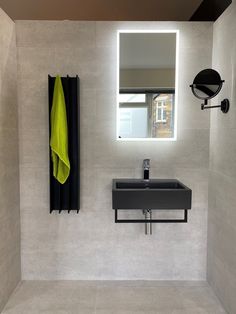 a bathroom with a sink, mirror and towel hanging on the wall next to it