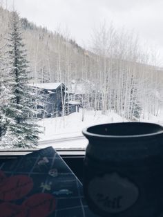 a view from the inside of a car looking out at snow covered mountains and trees