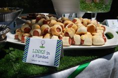 a table topped with lots of hot dogs covered in marshmallows