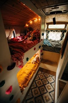 the interior of a camper with bunk beds, lights and rugs on the floor