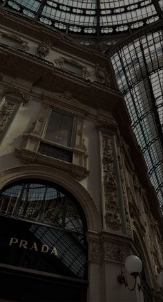 the inside of a building with glass and iron roofing on it's sides