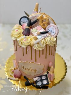 there is a cake with makeup on it and gold trimmings around the top