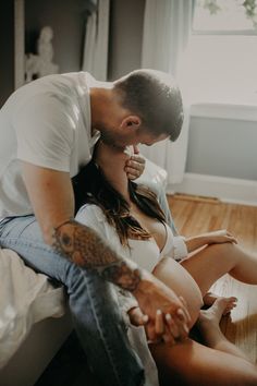 a man and woman sitting on the floor with their hands touching each other's butts