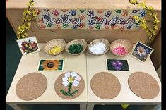 the table is set up with pictures, flowers and handprints on paper plates