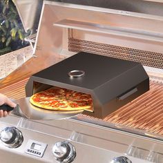 a pizza is being cooked on an outdoor grill