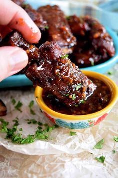 someone dipping some food into a small bowl