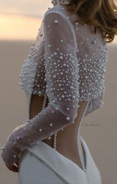 the back of a woman's dress with pearls on it