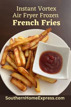 french fries on a white plate with ketchup and sauce in a small bowl