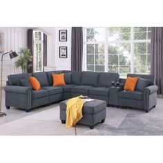 a living room with gray couches and orange pillows