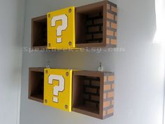 two wooden boxes with question marks on them are hanging from the wall next to each other