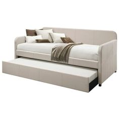 a white daybed with two pillows on it and a pull out bed in the middle