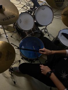 a man sitting on the floor playing drums