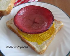 a sandwich with jelly on it sitting on a plate next to a slice of bread