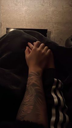 a person laying in bed with their arm wrapped around the edge of his body and hand on top of him