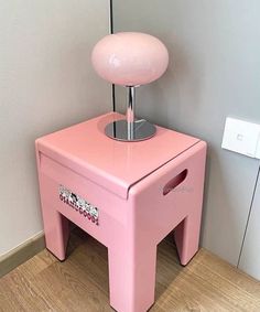 a pink table with a lamp on top