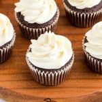 cupcakes with white frosting on a wooden board