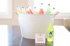 a bucket full of soda bottles sitting on top of a table next to a bottle opener