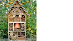 a bird house made out of wood in the middle of flowers