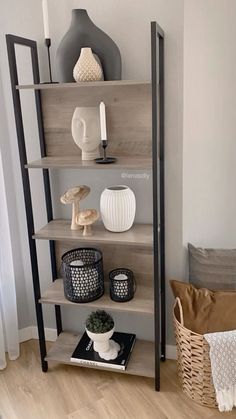 a shelf with vases and other items on it in the corner of a room