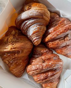 there are many croissants in the box and one has chocolate on it