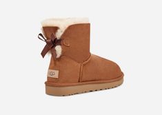 Our iconic boot has been updated with the addition of delicate, silky bows for a charming, feminine aesthetic. Constructed from soft sheepskin, this multi-functional boot integrates a strong, feather-light sole to amplify cushioning and grip. It's an ideal match for a wide range of outfits, from athleisure wear to flowing dresses.This product was made in a factory that supports women in our supply chain with the help of HERproject, a collaborative initiative that creates partnerships with brands Mini Bailey Bow Uggs Outfit, Bailey Bow Uggs Outfit, Ugg Mini Bailey Bow, Cute Uggs, Uggs With Bows, Mini Baileys, Bailey Bow Uggs, Bow Boots, Ugg Mini