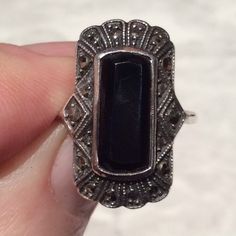 Stunning Art Deco black faceted onyx and marcasite silver ring. Dating from the 1920's the Jazz era. The  black onyx is set in the centre of this lovely Art Deco ring. It is firmly roll over silver set, and the black onyx has a lovely border of sparkling rose cut marcasites, which has a fan shaped pattern top and bottom of the ring, and diamond and half diamond shaped sides, all set with sparkly marcasites. A quality touch. The ring is in a good antique condition, but the onyx does have a chip on the onyx and this is featured on the second to last picture. The chip is a slightly more opaque black colour, but does not notice too much, as it is at the end of the faceted onyx, so slightly melts into the onyx cut facets of the stone. The marcasites have a few tiny nicks, only noticeable with a Victorian Black Sterling Silver Rings, Victorian Style Black Sterling Silver Rings, Ornate Black Sterling Silver Rings, Antique Black Jewelry Stamped 925, Vintage Sterling Silver Ring With Black Enamel, Vintage Sterling Silver Rings With Black Enamel, Art Deco Onyx Ring With Black Enamel, Art Deco Silver Onyx Jewelry, Vintage Onyx Black Rings