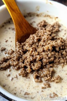 a bowl filled with oatmeal and a wooden spoon sitting on top of it