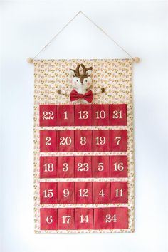 a red and white calendar hanging on a wall with a stuffed animal in the middle