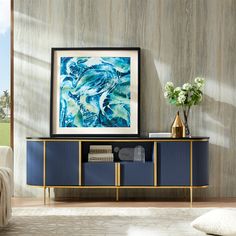 a blue and gold sideboard in a living room next to a white couch with a painting on the wall