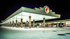 an empty gas station at night with the lights on