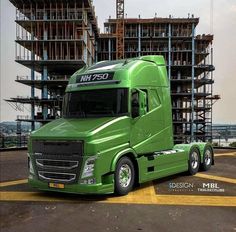 a green semi truck parked in front of a building under construction