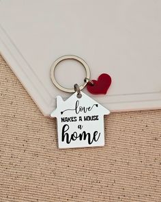 a keychain that says love makes a house to home with a heart on it