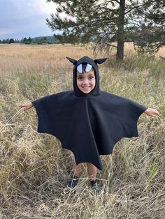 🦇 Fleece Bat Cape for Kids - Vampire Bat Costume with Hood, Ears, and Fangs 🦇 Let your little one take flight in our cozy, black fleece Bat Cape! 🖤 Perfect for Halloween, dress-up days, or imaginative play, this costume will make your child feel like a real vampire bat. ️ Crafted from soft, durable fleece, this cape is designed for comfort and ease. The pullover style allows for quick and hassle-free dressing, making it perfect for kids on the go. 🧒 The attached hood features charming vampir Diy Bat Costume Kids, Diy Kids Costumes For Boys, Bat Costume Diy, Bat Costume Kids, Toddler Bat Costume, Vampire Bat Costume, Kids Bat Costume, Diy Bat Costume, Bat Cape