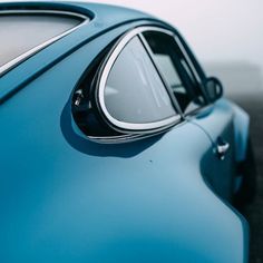 the side view mirror of a blue sports car