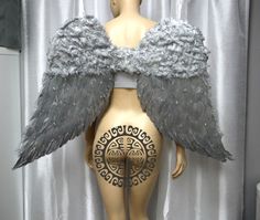 a mannequin with grey wings on it's back