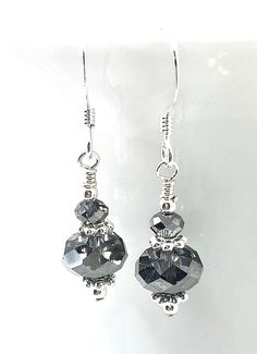 "Stunning Swarovski Crystal Silver Night (like a shiny silvery dark gray-black color) crystals and sparkling silver contrasting accents handcrafted on sterling silver French ear wires. These beautiful earrings have a silvery shimmer that will dress up any outfit. Finished length is about 1\". Available in 2 styles: Bicone bead on top - Style 1 Rondelle bead on top - Style 2 Please convo us with any questions. Perfect for prom, wedding guest, holidays, New Year's Eve or any day you need a little Crystal Earrings Diy, Diy Earrings Easy, Diy Jewelry Earrings, Jewelry Making Earrings, Peridot Earrings, Swarovski Crystal Jewelry, Swarovski Beads, Homemade Jewelry, Swarovski Crystal Earrings