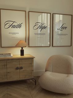 two framed posters on the wall next to a chair and lamp in a living room