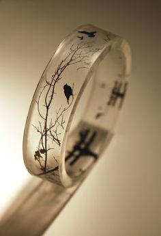 a ring that has birds on it with trees in the middle and branches growing out of it