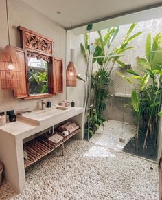 a bathroom with two sinks and a mirror on the wall next to a potted plant