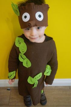 a young boy wearing a costume made to look like a creature with green leaves on his head