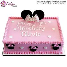 a pink birthday cake decorated with minnie mouse ears