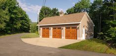 a two car garage sits on the side of a road in front of some trees