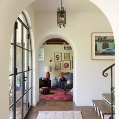 an archway leads to the living room and dining area in this mediterranean - style home