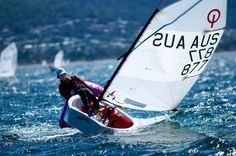 a person windsurfing on the water with other boats in the background